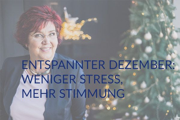 Mann im Anzug sitzt barfuß und entspannt auf der grünen Wiese. (Symbolbild)