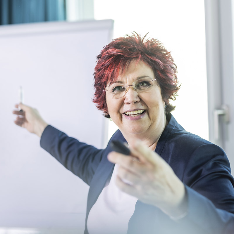 Carmen Reuter steht gutgelaunt vor dem Flipchart