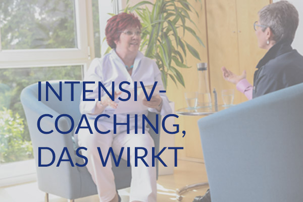 Carmen Reuter, Business und Life Coach in Karlsruhe, steht fröhlich und gutgelaunt im Seminarraum