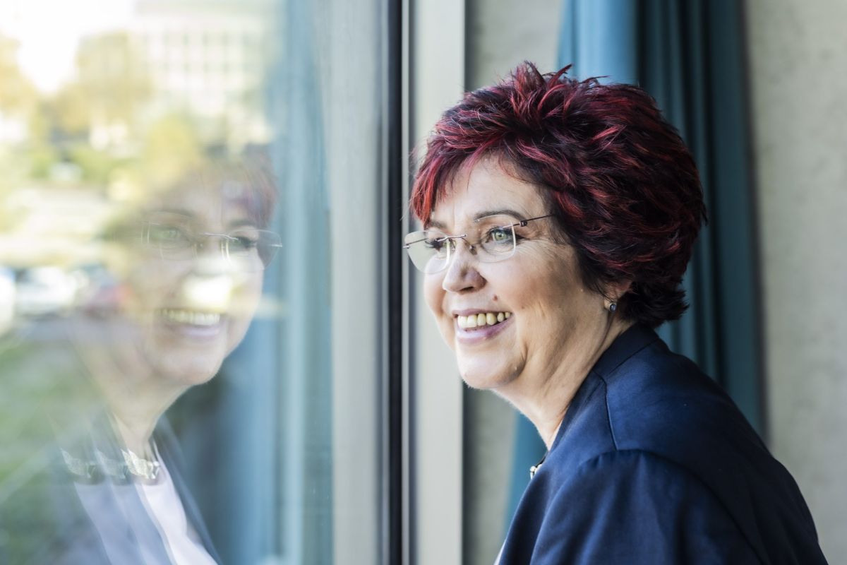 Negative Glaubenssätze auflösen — Frau sitzt nachdenklich am Fenster.